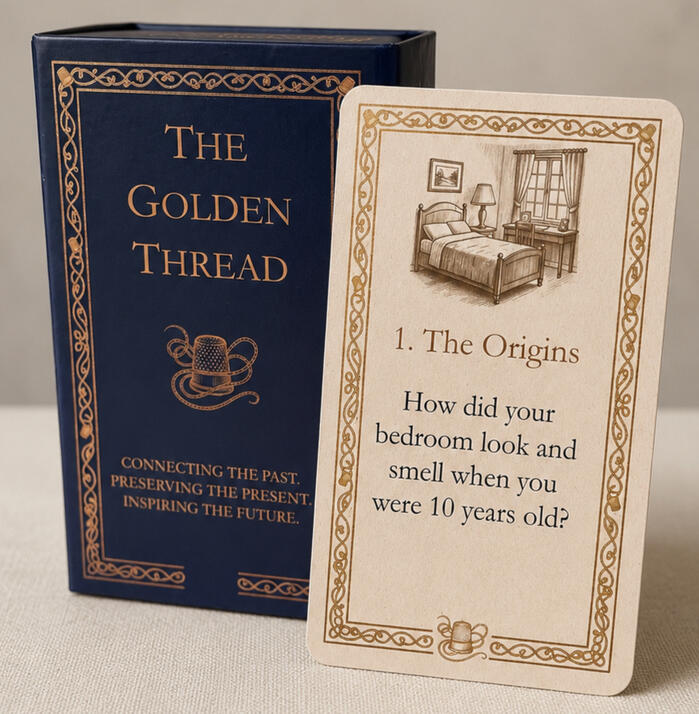 A product hero shot of the Golden Thread showing the deep blue box with golden etching, together with a sample card.