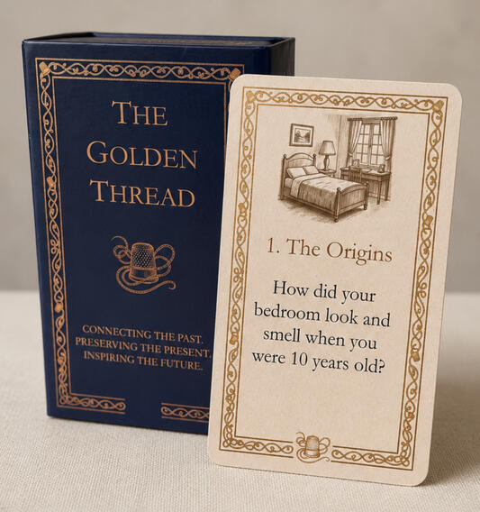 A product hero shot of the Golden Thread showing the deep blue box with golden etching, together with a sample card.